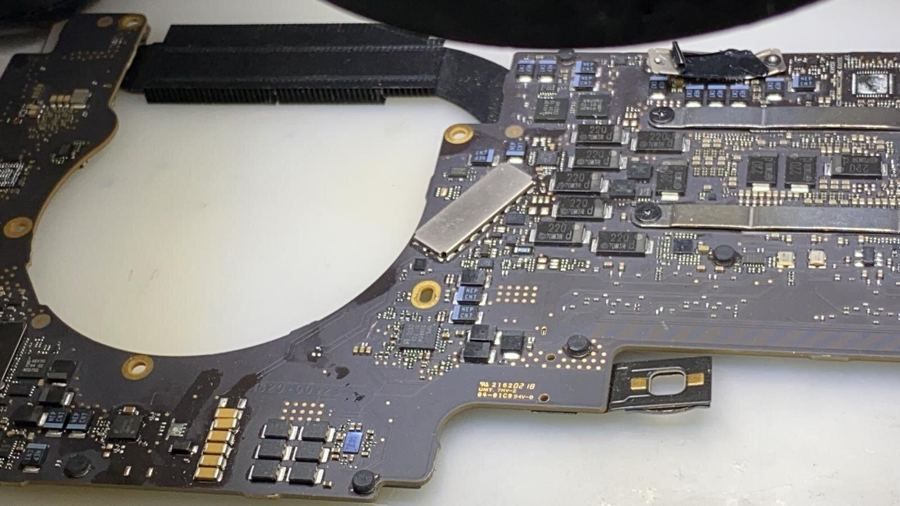 Close-up of a MacBook logic board during component-level repair
